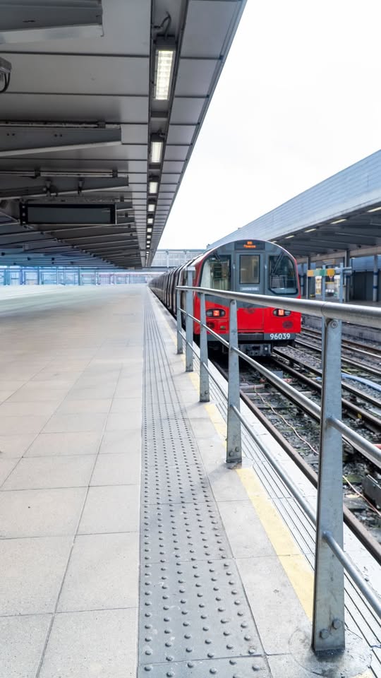 Red and white London Underground tube train at an outdoor station platform